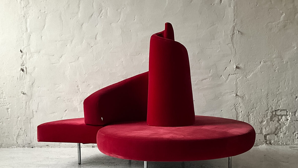 Czerwona sofa Edra Tatlin projektu Mario Cananzi i Roberto Semprini z 1989 roku, spiralne oparcie i welurowa tapicerka.
